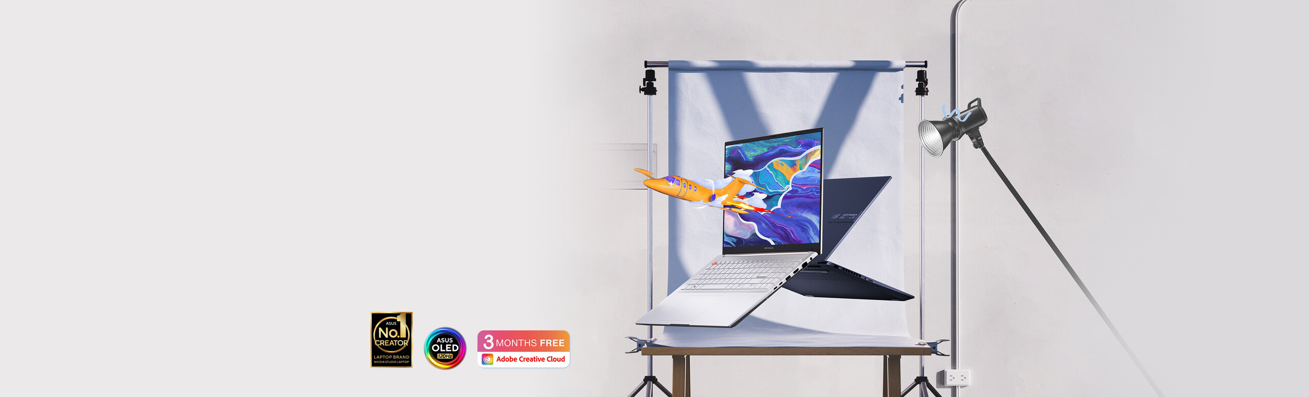Vivobook Pro 15/16 OLED presenting its design from front and back along with an airplane popping out form the screen, with ASUS 120 Hz OLED badge, No.1 creator laptop brand badge and 3 month free Adobe Creative Cloud badge.