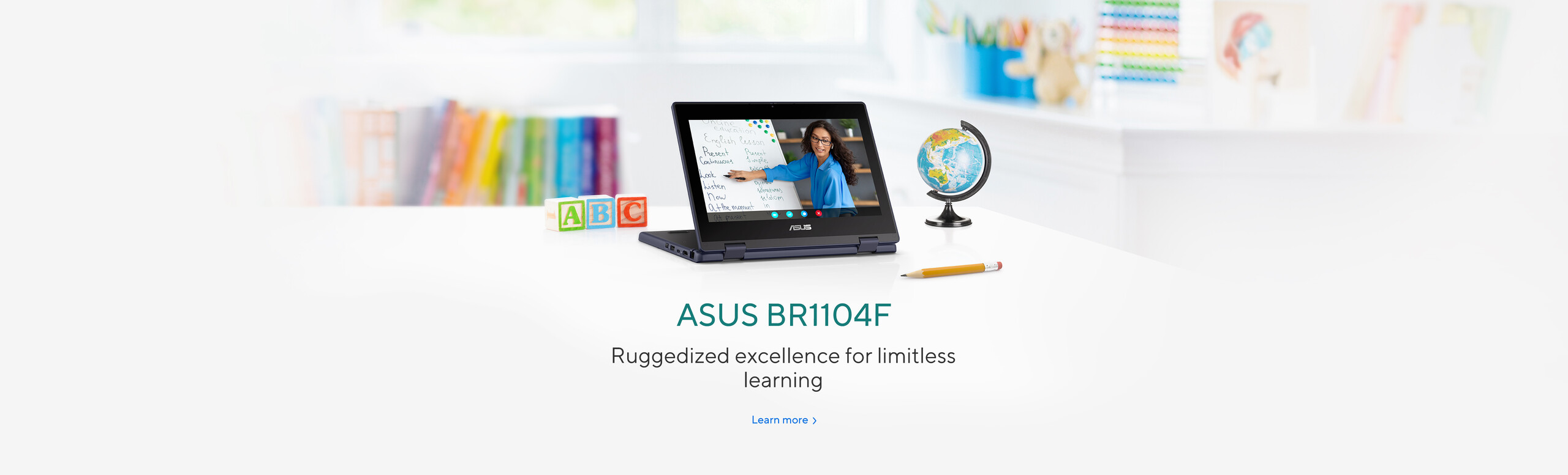 ASUS BR1104F laptop u učionici, prikazan u tent režimu sa engleskim časom na ekranu, okružen edukativnim blokovima, globusom i školskim priborom – izdržljiv laptop za obrazovanje, Windows 11 Pro
