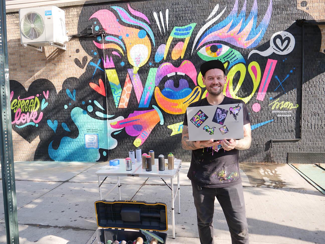 WOW the World Mural with artist standing with ASUS laptop