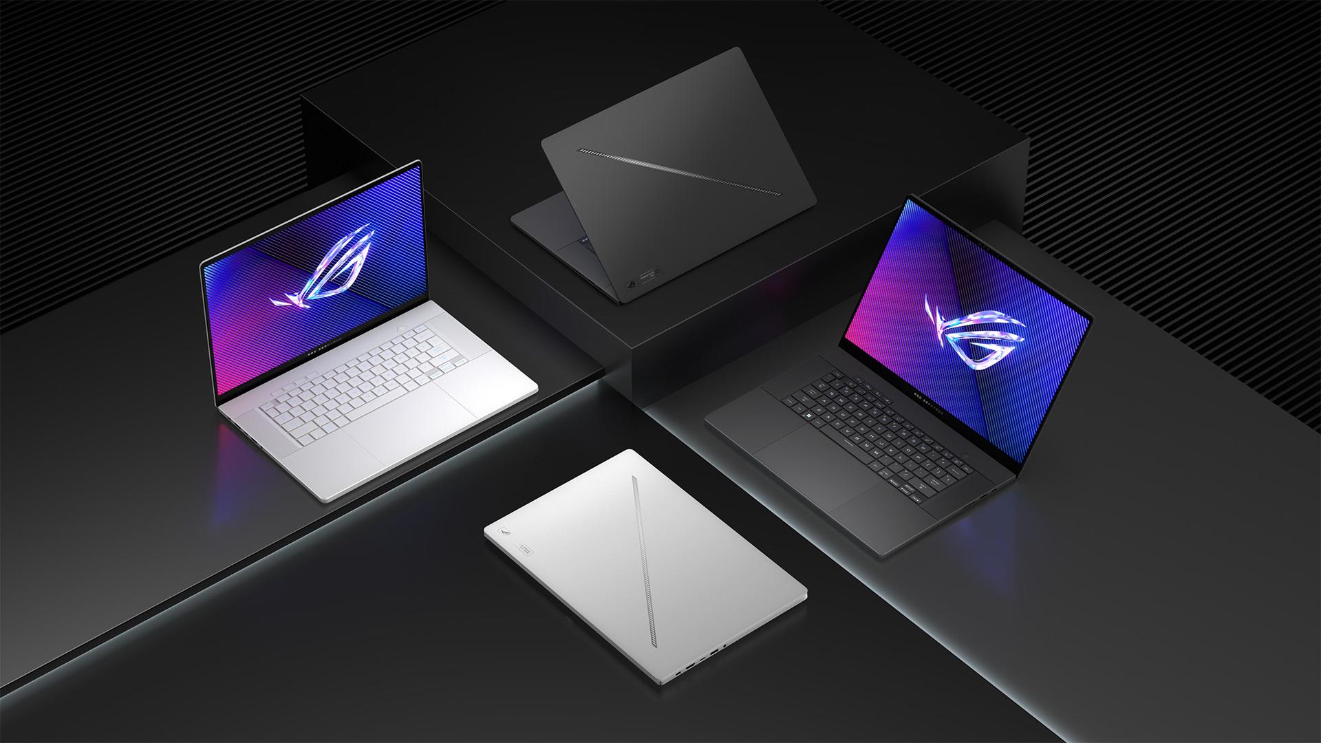 Four Zephyrus G16 laptops, with two each in Eclipse Gray and Platinum White, sitting on blocks of different heights, with their laptop lids open at different angles, on a dark gray background