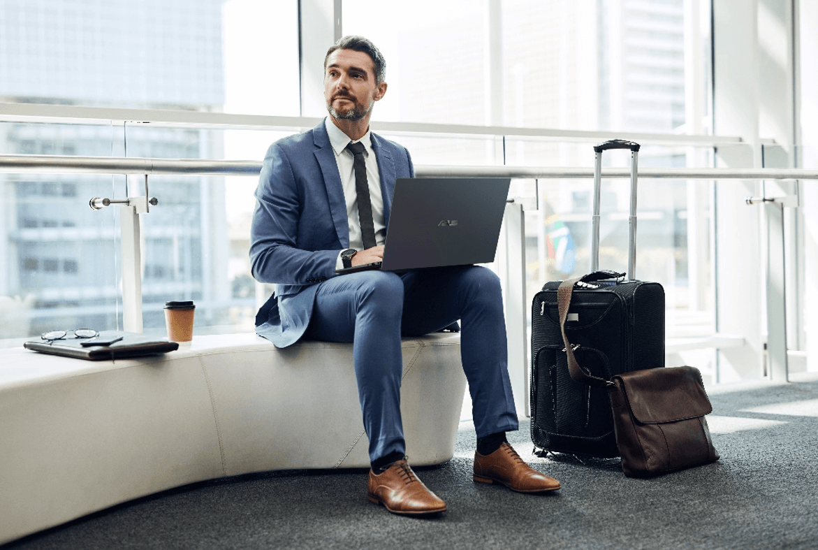 Man sitting with an ASUS laptop in his lap.